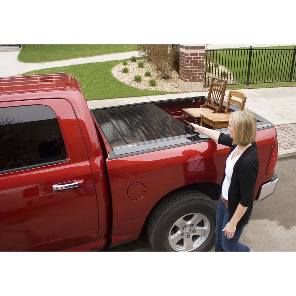 Women touching her red pick-up truck while loading items.