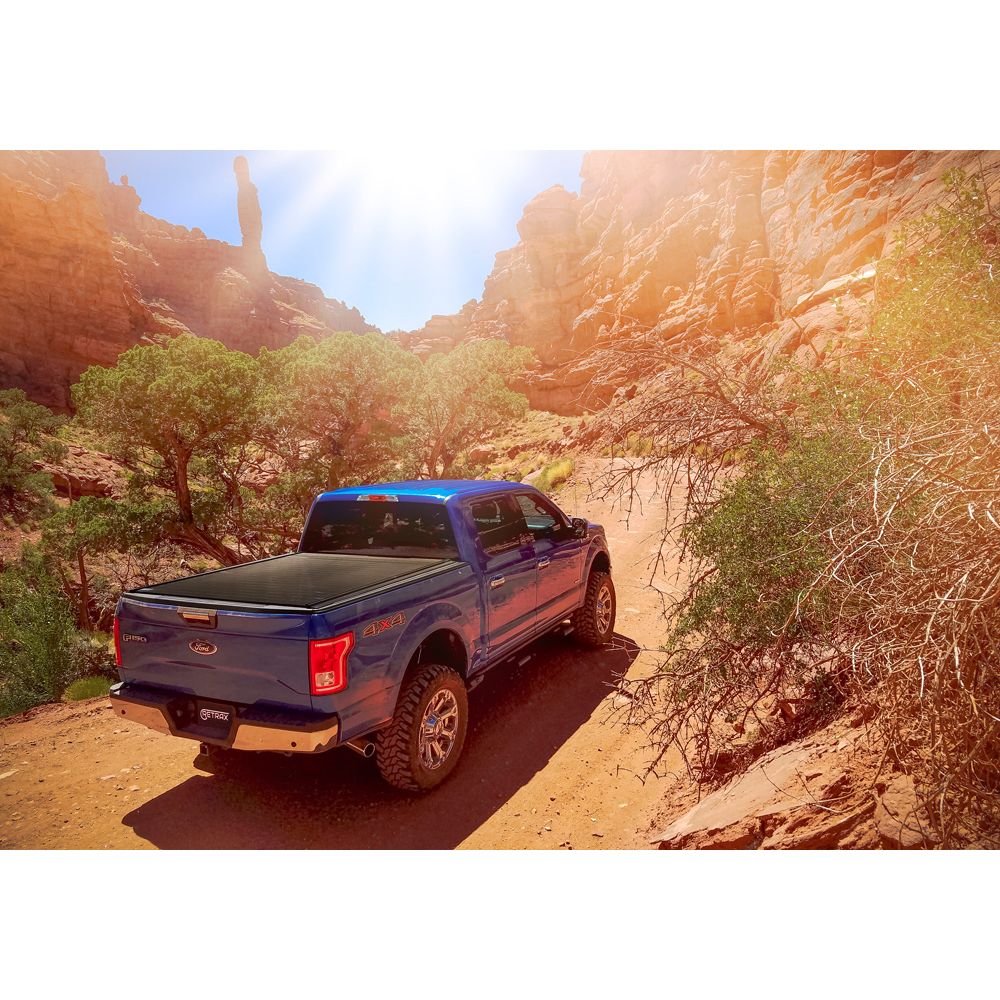 Blue pick-up truck driving in a canyon.