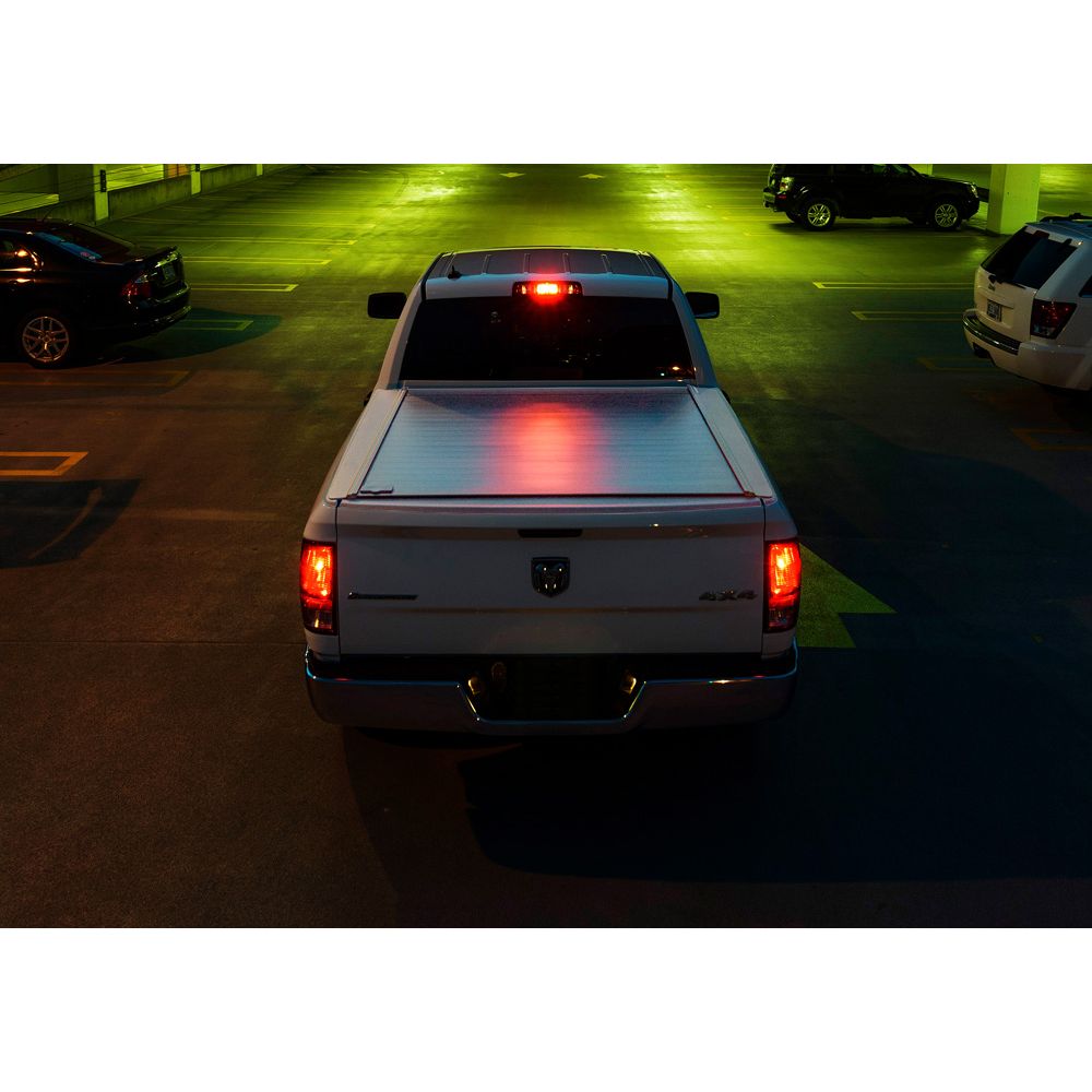 White truck with it's lights on at night time. 